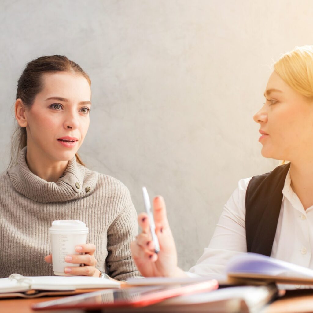 Two women sat at a desk to Negotiate